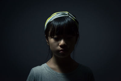 Close-up of girl against black background