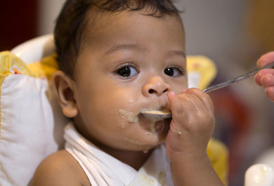 Portrait of cute boy eating food at home