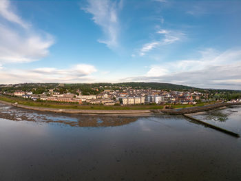 Scenic view of river by buildings against sky in city