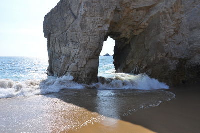 Scenic view of rocks in sea against sky