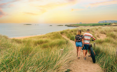 Unrecognizable couple with a fat bike taking a walk through the beach dunes