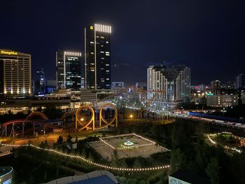 Illuminated bridge and buildings in city at night