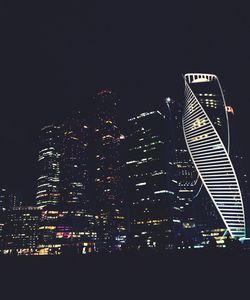 Low angle view of illuminated cityscape against sky at night