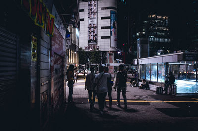 People walking on street at night in city