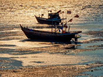 The old wooden fishing boat on a pebble beach on beautiful sunrise.