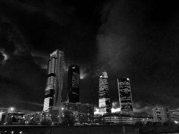 Low angle view of illuminated buildings against sky at night