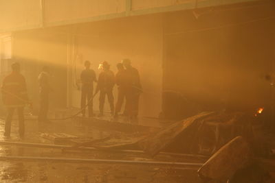 Firefighters spraying water in burning building