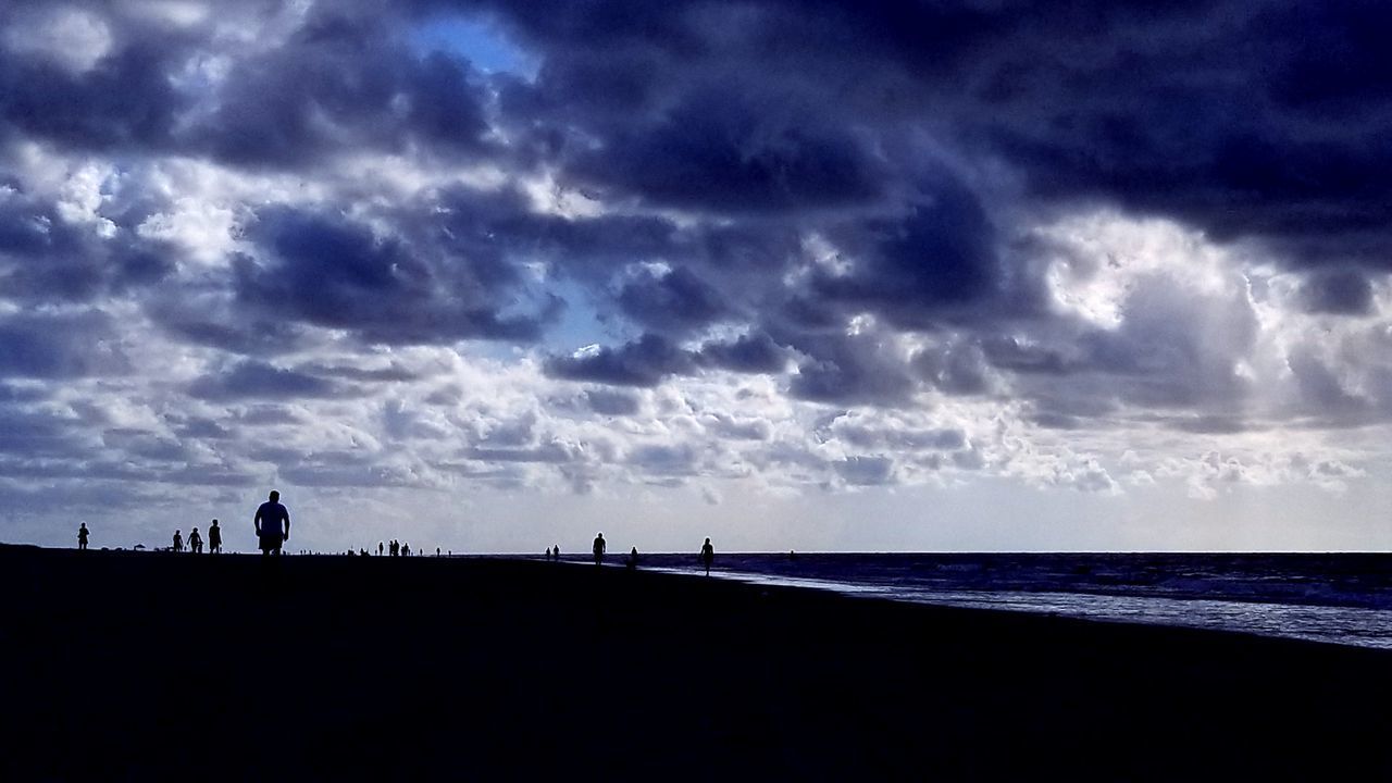 PEOPLE ON BEACH AGAINST SKY