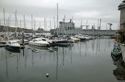 Sailboats moored in harbor