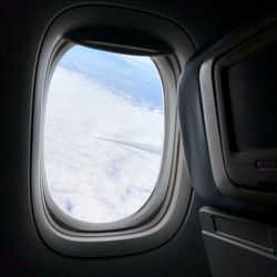 Cloudy sky seen through airplane window