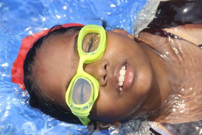 Portrait of girl lying in swimming pool