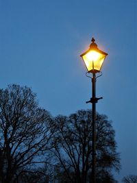 Low angle view of illuminated street light against sky at night