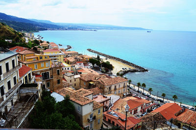 High angle view of townscape by sea against sky