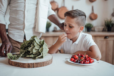 Midsection of man holding ice cream on table