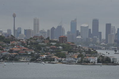 Cityscape by sea against sky