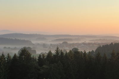 Scenic view of trees against sky during sunset