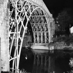 Reflection of bridge in water against sky