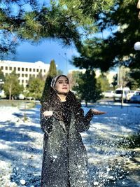 Full length of woman standing on snow covered tree