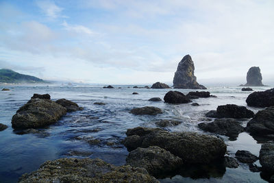 Rocks on sea shore against sky