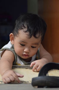 Close-up of cute baby boy lying on floor at home