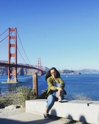 Full length of woman against bridge against clear blue sky