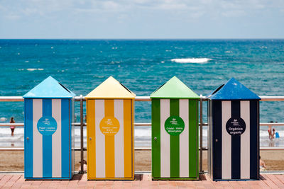 Multi colored umbrellas on beach against sky