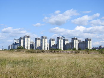 Buildings on field against sky in city