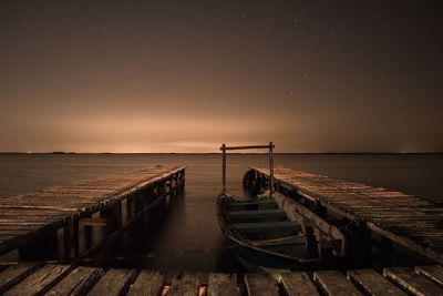 Pier over sea against clear sky during sunset