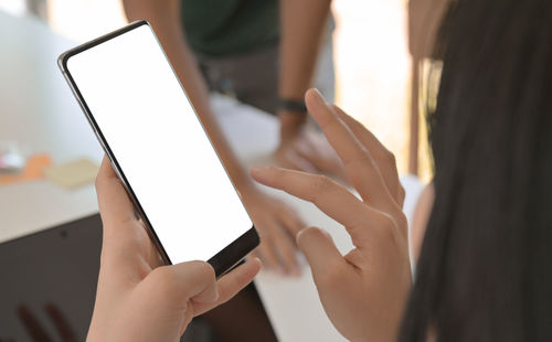 Midsection of woman holding mobile phone