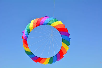 Low angle view of umbrella against clear blue sky