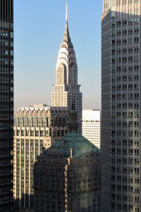 Buildings in city against clear sky