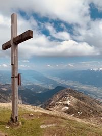 Cross on landscape against sky