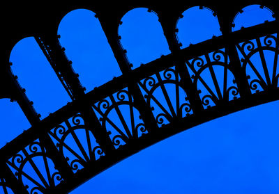 Low angle view of silhouette built structure against blue sky