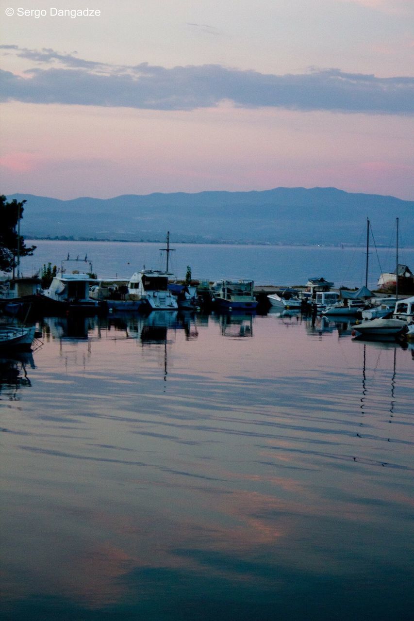 BOATS MOORED AT HARBOR AGAINST SKY