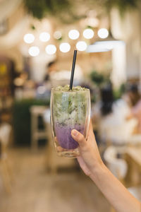 Cropped hand of woman holding drink in restaurant