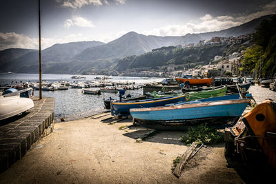 Boats moored at harbor against sky