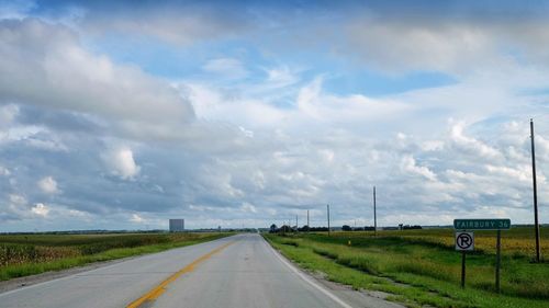 Road passing through land against sky