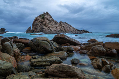 Rocks on beach against sky