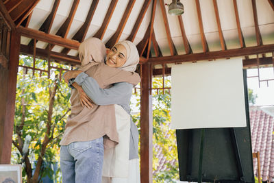 Rear view of woman standing by window