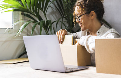 Young businesswoman using laptop while sitting on sofa