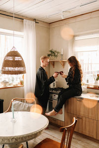 A couple in love have breakfast and drink tea in a decorated eco-style kitchen in a country house