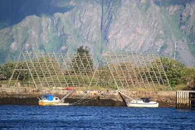 Scenic view of boats in water next to bamboo structure