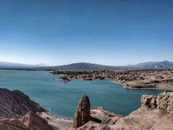 Panoramic view of sea and mountains against clear blue sky