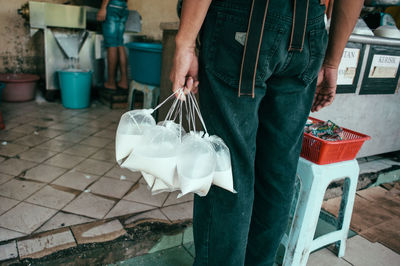 Midsection of man holding milk packets