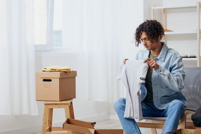 Side view of young woman using mobile phone at home