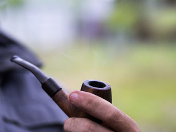 Close-up of hand holding cigarette