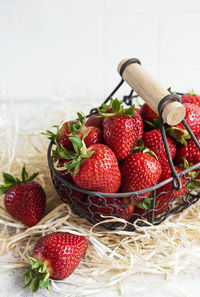 Fresh ripe delicious strawberries in a basket on a gray stone background
