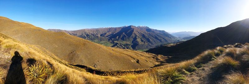 Panoramic view of landscape and mountains against clear blue sky