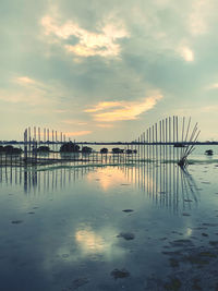 Pier on sea against sky during sunset