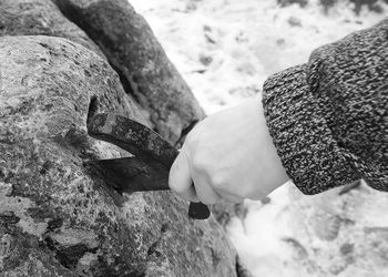 Close-up of hand holding rock at beach